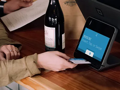Customer paying by card at a countertop payment terminal
