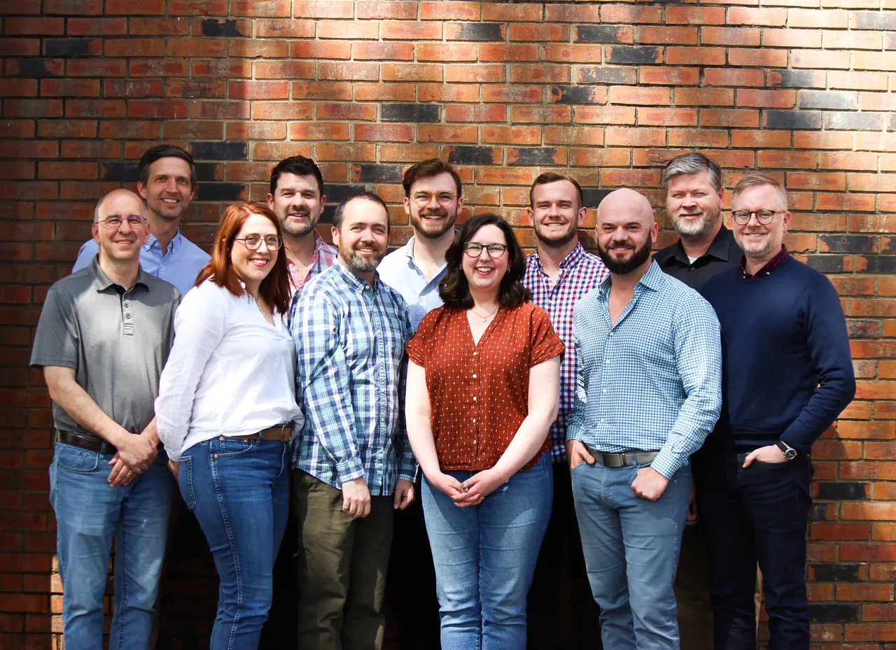 The Clear Function team standing together in front of a brick wall